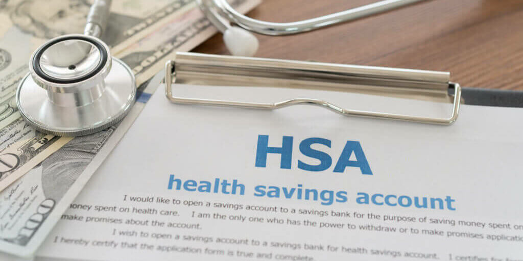 health savings account HSA concept with application form,dollar money, stethoscope on desk.