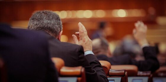 Member of Romanian Parliament is voting by raising his hand