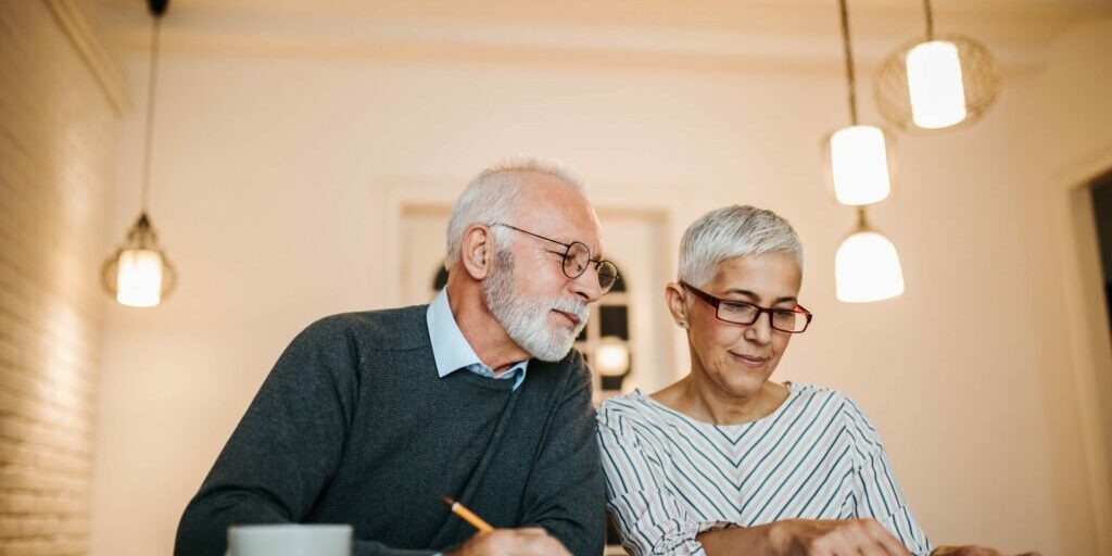 Mature couple doing some paperwork and calculations at home