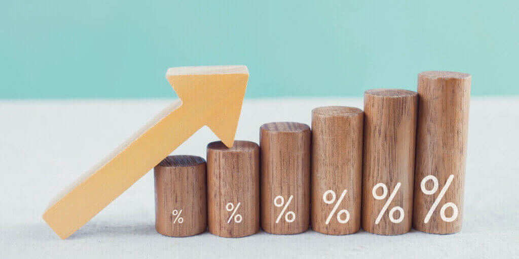 Wooden blocks with percentage sign and arrow up, financial growt