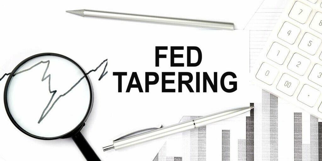 FED TAPERING text on the document with pen,graph and magnifier,calculator